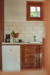 eine Küche mit einer Spüle und einem Kühlschrank in der Unterkunft Villa Estrela Bungalow in Itacaré