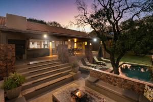 un patio trasero con una hoguera y una casa en Elements Private Golf Reserve House 296, en Bela-Bela