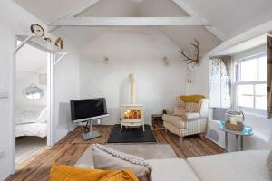 a living room with a fireplace and a tv at Carvossa, Marazion in Marazion