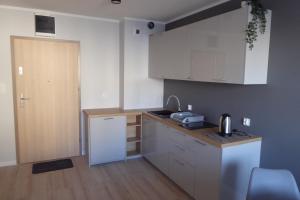 a kitchen with white cabinets and a counter top at Dziwnówek Słoneczne Tarasy Gray in Dziwnówek