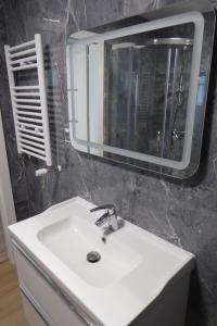 a bathroom with a white sink and a mirror at Dziwnówek Słoneczne Tarasy Gray in Dziwnówek +10 photos