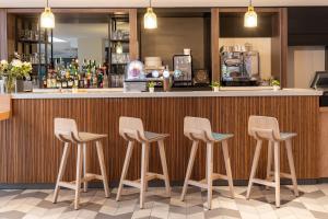 a row of stools at a bar in a restaurant at Holiday Inn Lyon Vaise, an IHG Hotel in Tassin-la-Demi-Lune