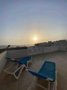 un par de sillas sentadas en la azotea en Magnifique appartement avec terrasse prive vue mer, en Essaouira