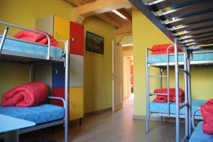 a room with three bunk beds and a table at Hostel Curavacas in Triollo