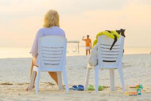 two people sitting in chairs on the beach at Sunset Beach View in Dhangethi