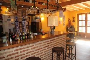 a bar in a restaurant with chairs and bottles of wine at Hostel Curavacas in Triollo