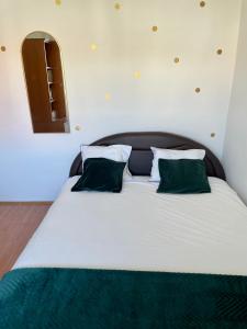 a large white bed with green pillows in a room at Apartman Luš in Sutivan