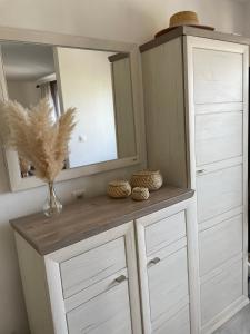 um armário branco com um espelho e um vaso sobre ele em Apartman Luš em Sutivan