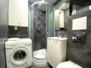 a bathroom with a washing machine and a shower at Forest - 23 Marca Sopot by Grand Apartments in Sopot