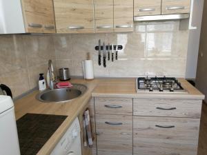 Una pequeña cocina con fregadero y estufa. en Šiauliai City Apartment, en Šiauliai 14 fotos más