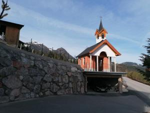 eine Kirche mit einem Kirchturm auf einer Steinmauer in der Unterkunft Resort Hanni Deisenberger in Fieberbrunn