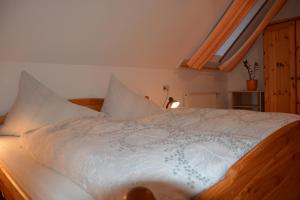 1 dormitorio con 1 cama con sábanas y almohadas blancas en Bauernhof Grain, en Feldbach