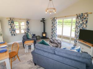 uma sala de estar com um sofá azul e uma televisão em Acorn Lodge em Stafford