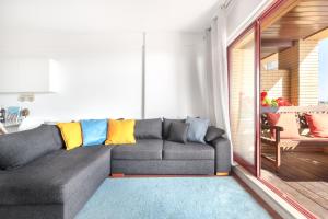 a living room with a gray couch with colorful pillows at Own Places - Ocean View Apartment in Matosinhos