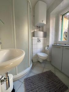 a white bathroom with a sink and a toilet at Casa David in Piran