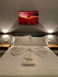 a bedroom with a bed with a picture on the wall at Hotel Real in Ishull-Lezhë