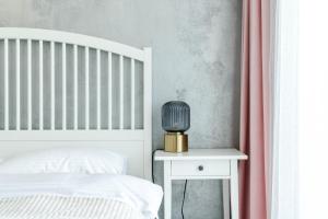 a bedroom with a bed and a table with a lamp at Apart B&V 701 in Braşov