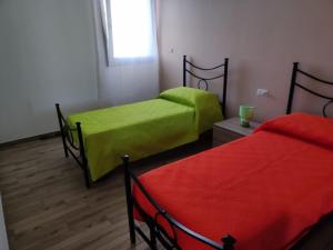 2 Betten mit grüner Bettwäsche in einem Zimmer in der Unterkunft CASA VACANZE LA PERLA in Presicce