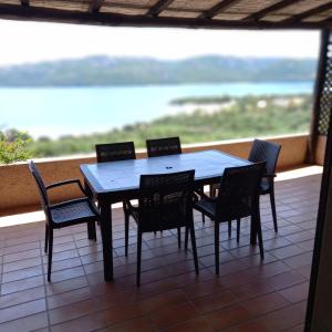 a table and chairs on a balcony with a view of the ocean at Casa Debby in Palau