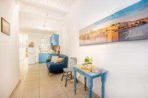 sala de estar con mesa y sofá azul en Valletta Ferry Apartment en La Valeta