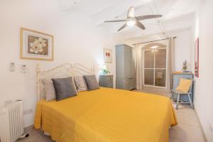 1 dormitorio con 1 cama amarilla y ventilador de techo en Valletta Ferry Apartment en La Valeta