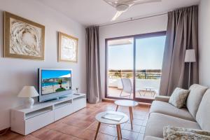 un salon avec un canapé et une télévision dans l'établissement Carmen de la Bahía, à La Herradura