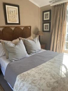 een slaapkamer met een groot bed met kussens bij Lakeside Cottage on Spring Grove in Nottingham Road
