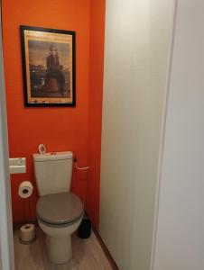 a bathroom with a toilet and a painting on the wall at Maison du martin pêcheur à Lannion in Lannion