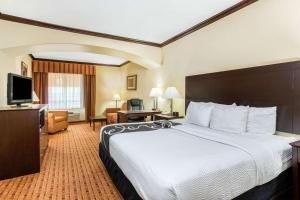 a hotel room with a bed and a television at La Quinta by Wyndham Ennis in Ennis
