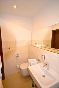 a bathroom with a white toilet and a sink at Hotel Kehrenkamp in Hagen