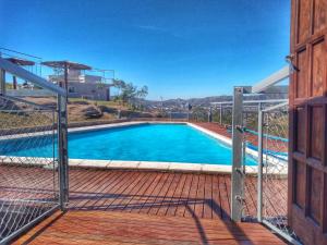 een uitzicht op een zwembad door een hek bij Vista del Lago in Villa Carlos Paz +15 foto's