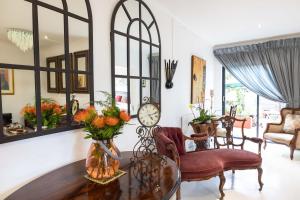 a living room with a table and chairs and a clock at Cape Pillars Boutique Hotel in Durbanville