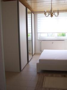 ein Schlafzimmer mit einem weißen Bett und einem Fenster in der Unterkunft Apartment Ilmtal Jena in Bad Berka