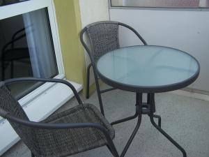 einem Glastisch und einem Stuhl neben einem Tisch und einem Stuhl in der Unterkunft Apartment Ilmtal Jena in Bad Berka