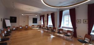 a large room with chairs and tables and windows at Schloss Gumpoldskirchen in Gumpoldskirchen