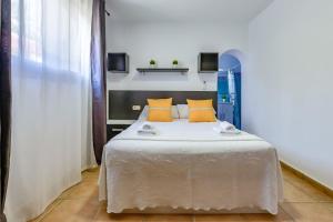 une chambre avec un lit avec des oreillers jaunes dans l'établissement Villas Guzman - Mouna, à Calp 38 autres photos