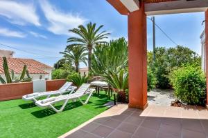 卡爾佩的住宿－Villas Guzman - Mouna，一个带草坪椅和棕榈树的庭院