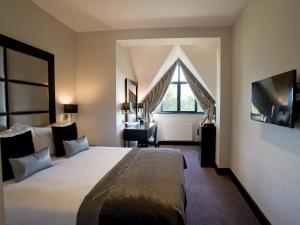 a hotel room with a large bed and a window at The Lodge at Kingswood in Epsom