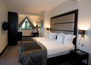 a hotel room with a large bed and a window at The Lodge at Kingswood in Epsom