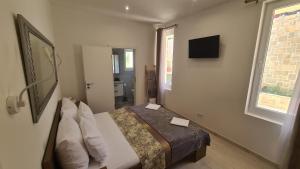 a bedroom with a bed and a television on the wall at Apartments Tanja in Zavalatica