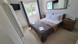 a small bedroom with a bed and a mirror at Apartments Tanja in Zavalatica
