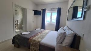 a bedroom with a bed and a window and a television at Apartments Tanja in Zavalatica