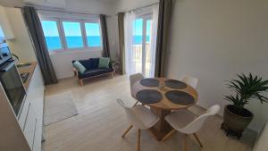 a table and chairs in a living room with the ocean at Apartments Tanja in Zavalatica