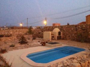 a swimming pool in a yard next to a stone wall at Casa yeya in Tiscamanita