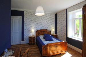 - une chambre avec un lit doté d'oreillers bleus et d'une table dans l'établissement Au Fil du Temps, à Fougerolles