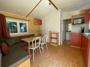 博凱爾的住宿－Logement 2 chambres avec jacuzzi sur terrain en pleine nature，厨房以及带桌椅的起居室。