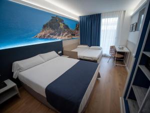 a hotel room with a bed and a painting of the ocean at Hotel Don Juan Tossa in Tossa de Mar