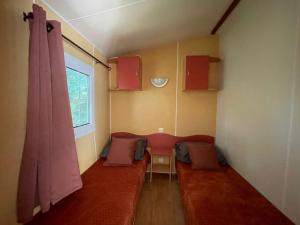 a room with a red couch and a window at Logement 2 chambres avec jacuzzi sur terrain en pleine nature in Beaucaire