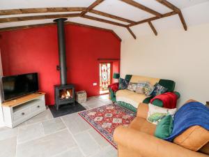 a living room with a couch and a tv and a fireplace at Lime Kiln Cottage in Bridgend