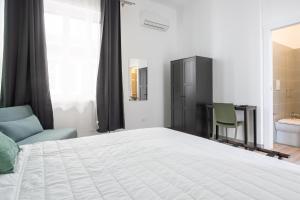 sypialnia z dużym białym łóżkiem i łazienką w obiekcie Le Cinque Stanze Palermo Room&Breakfast w mieście Palermo